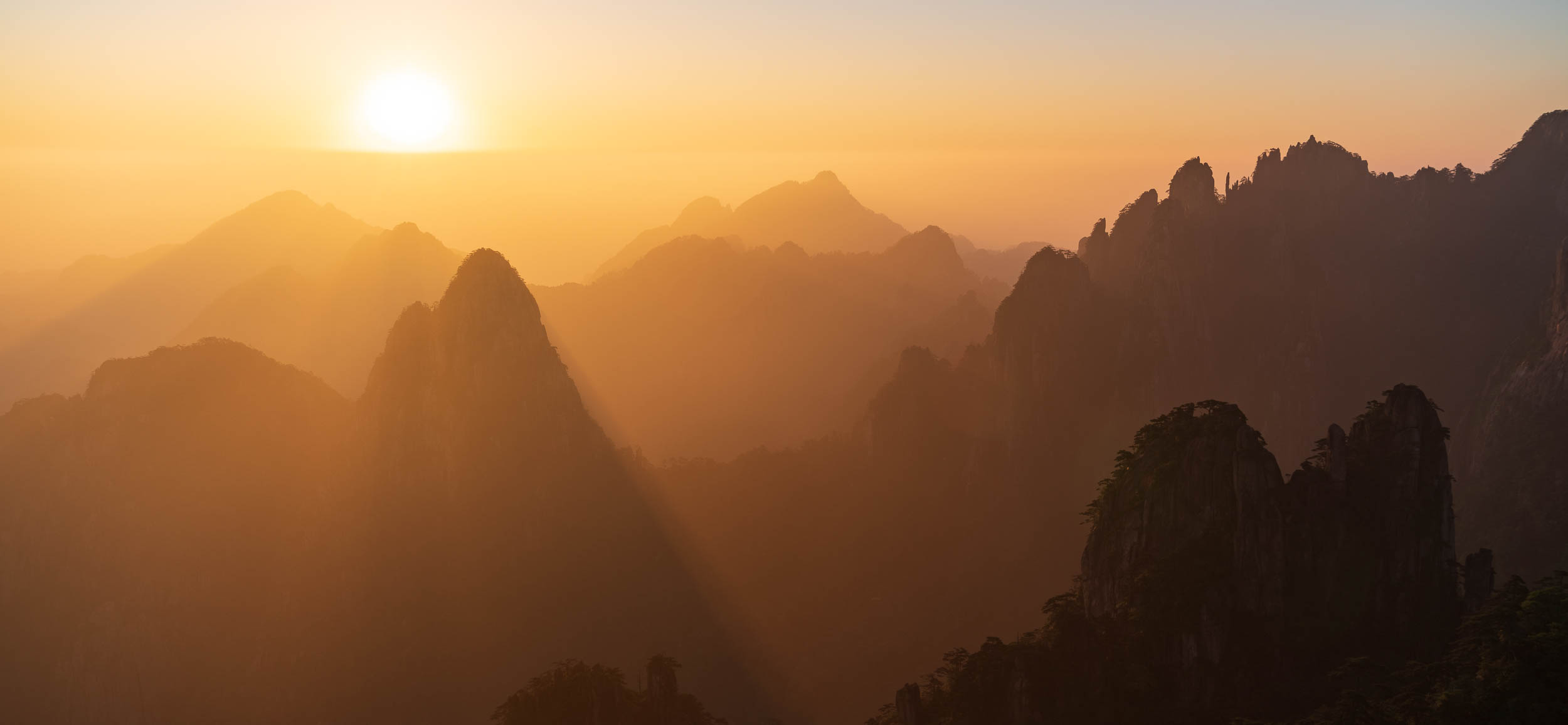 Golden mountain peaks at sunrise in Huangshan